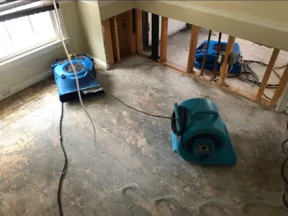 Blue air movers drying a room with the lower walls opened in a Kernersville home